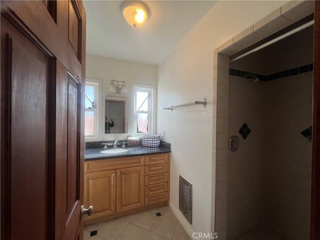 full bathroom featuring visible vents, tiled shower, tile patterned flooring, and vanity