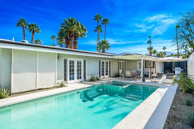 view of swimming pool with french doors and a patio