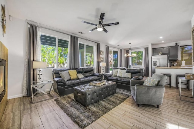 living room featuring ceiling fan with notable chandelier