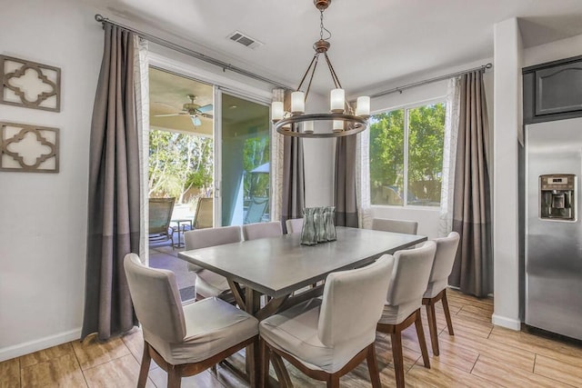 dining area with ceiling fan with notable chandelier