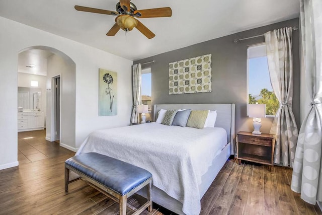 bedroom with ensuite bathroom, ceiling fan, and dark hardwood / wood-style floors