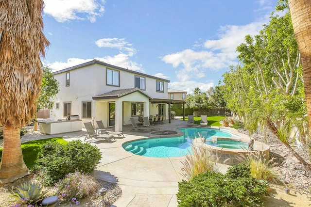 view of swimming pool with a patio area, an outdoor kitchen, and an in ground hot tub