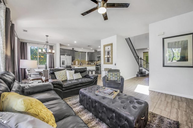 living room featuring light tile patterned floors and ceiling fan with notable chandelier