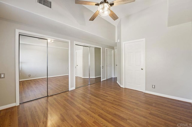 unfurnished bedroom with ceiling fan, two closets, and hardwood / wood-style flooring