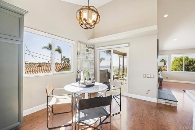 dining area with a high ceiling, dark hardwood / wood-style floors, and a notable chandelier