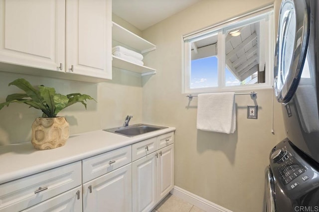 washroom with cabinets, light tile patterned flooring, stacked washer / dryer, and sink