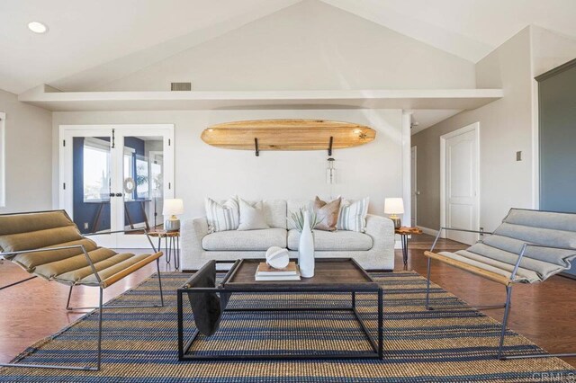 living room featuring hardwood / wood-style flooring, lofted ceiling, and french doors