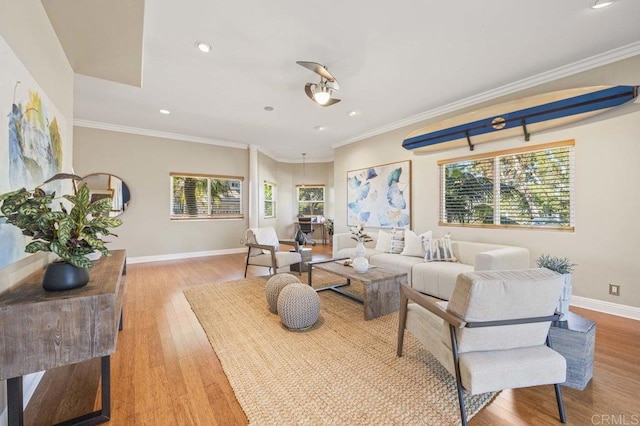 living room with light wood-type flooring, a wealth of natural light, and ornamental molding