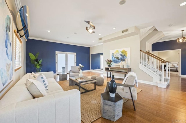 living room with hardwood / wood-style flooring, plenty of natural light, and crown molding