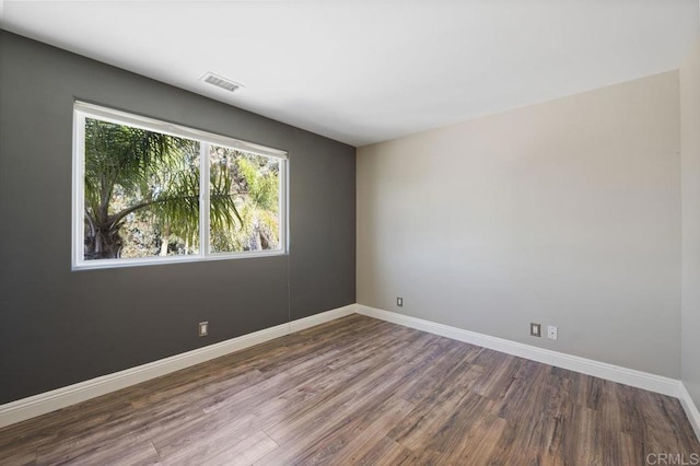 empty room with dark hardwood / wood-style flooring