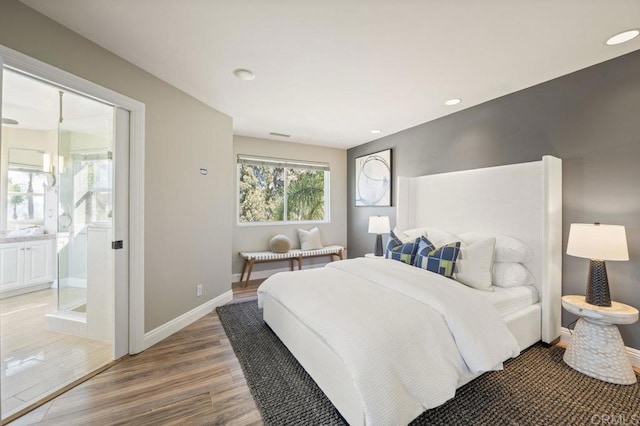 bedroom with hardwood / wood-style floors and ensuite bath