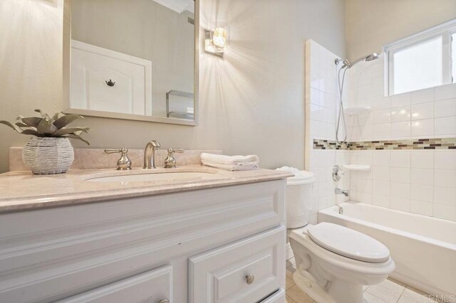 full bathroom with toilet, vanity, tile patterned flooring, and tiled shower / bath