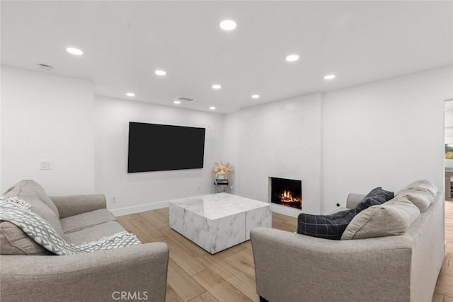 living room with light wood-type flooring and a fireplace