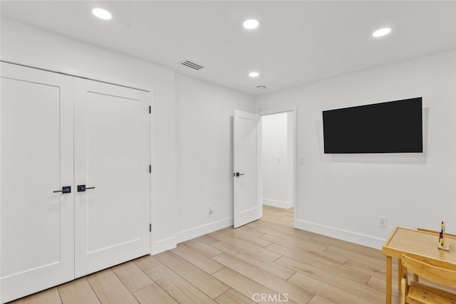 bedroom with a closet and light hardwood / wood-style floors