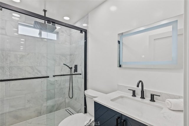 bathroom featuring toilet, a shower with shower door, and vanity