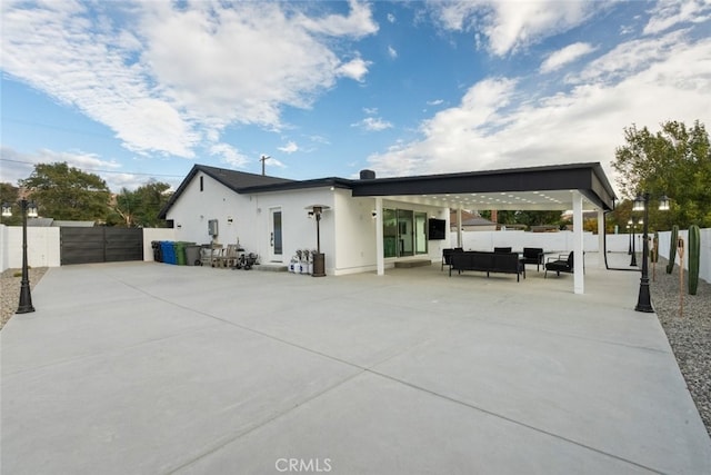 back of house with outdoor lounge area and a patio