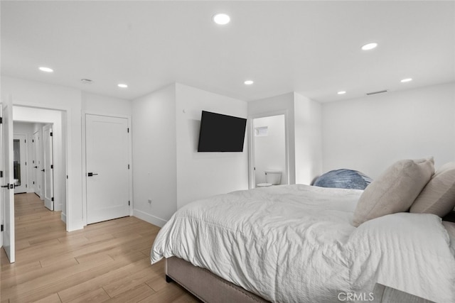 bedroom featuring ensuite bathroom and light hardwood / wood-style floors