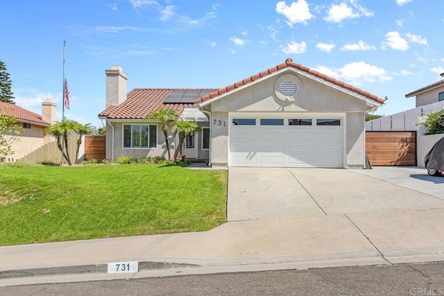 view of front of house featuring a garage, a front yard, and solar panels