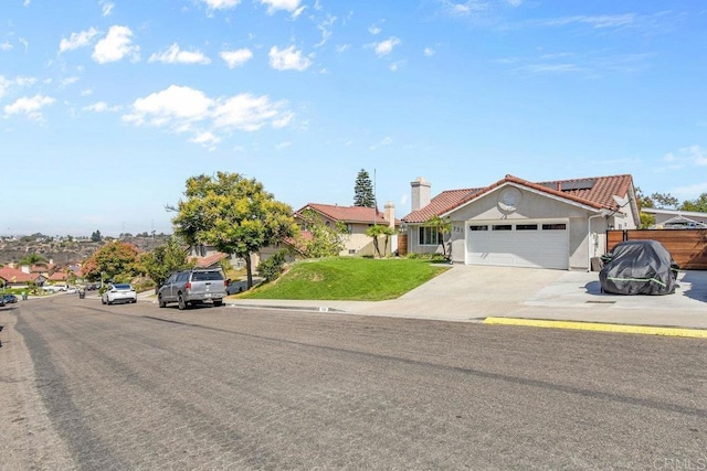 view of front of house featuring a front yard, a garage, and solar panels