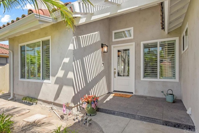 entrance to property featuring stucco siding