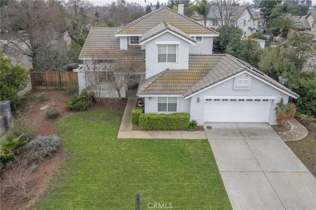 view of property with a garage and a front lawn