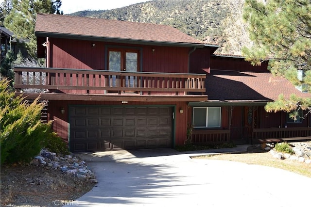 view of front of home featuring a garage, a mountain view, and a balcony