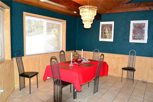 dining area with lofted ceiling, tile patterned flooring, a notable chandelier, wood walls, and wood ceiling