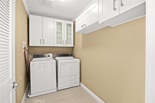 washroom with washing machine and dryer and cabinets