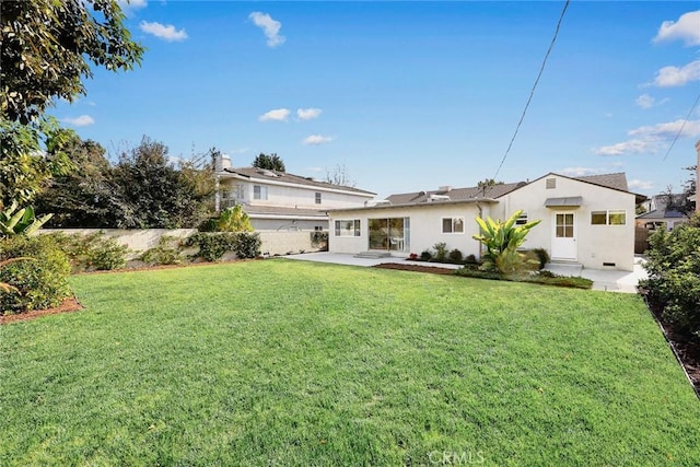 rear view of property featuring a patio area and a lawn