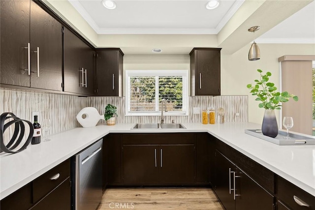 kitchen featuring dishwasher, decorative light fixtures, decorative backsplash, sink, and light hardwood / wood-style flooring