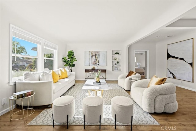 living room with hardwood / wood-style floors and built in shelves