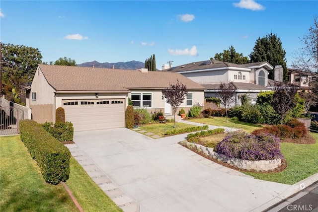 ranch-style home featuring a front lawn, a garage, and a mountain view