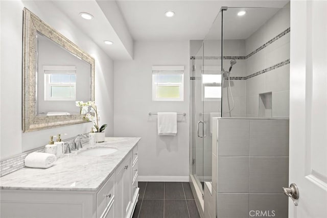 bathroom with a shower with shower door and vanity