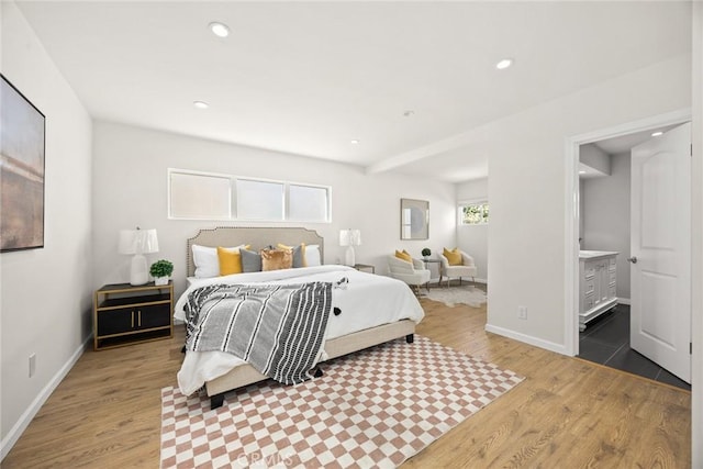 bedroom featuring hardwood / wood-style floors and ensuite bathroom