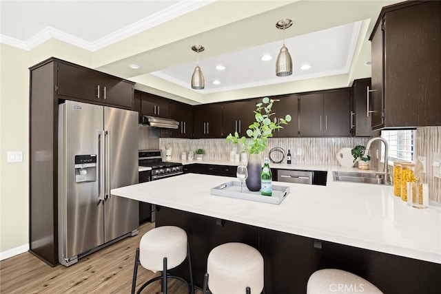 kitchen featuring sink, appliances with stainless steel finishes, kitchen peninsula, and a breakfast bar area