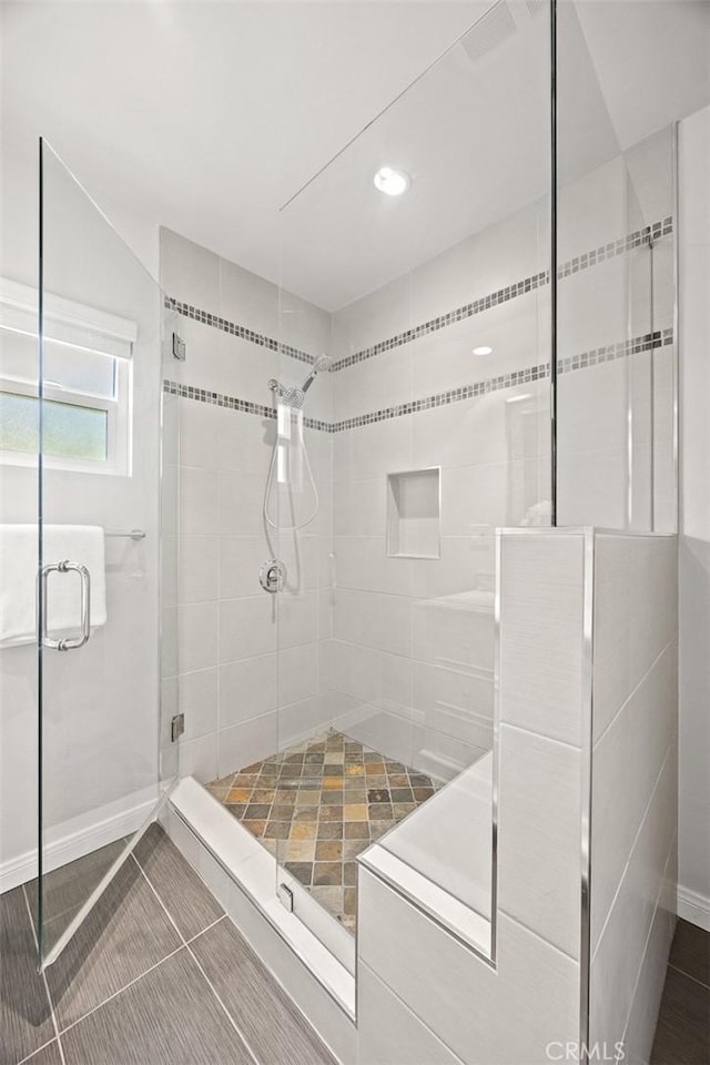 bathroom with a shower with door