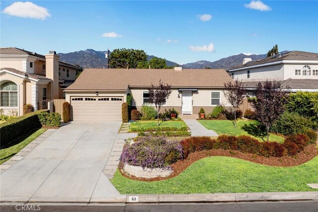 view of front of property with a front lawn, a garage, and a mountain view