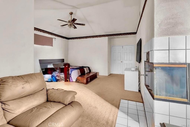 carpeted living room with ceiling fan and vaulted ceiling