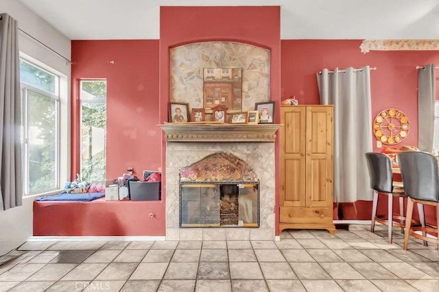 living room with a high end fireplace and tile patterned flooring