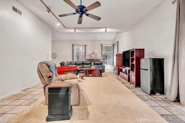 living room with vaulted ceiling, ceiling fan, light tile patterned floors, and rail lighting