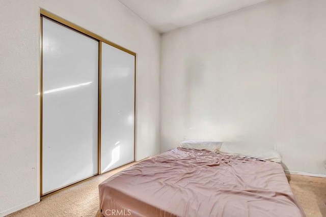 bedroom featuring light colored carpet and a closet