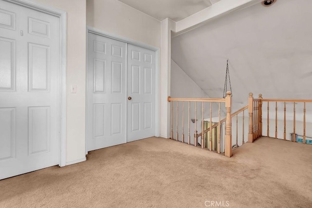 interior space with carpet floors and vaulted ceiling