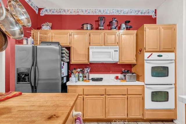 kitchen with light brown cabinets and white appliances