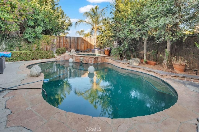 view of swimming pool with an in ground hot tub and a patio area