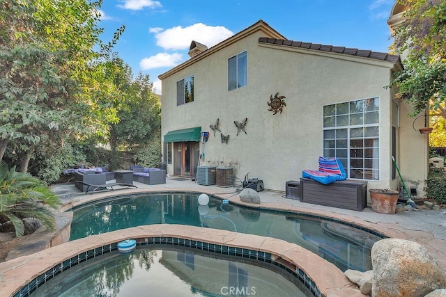 rear view of property with outdoor lounge area, a pool with hot tub, a patio, and central AC