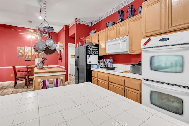 kitchen featuring ceiling fan, tile counters, light brown cabinets, white appliances, and hanging light fixtures