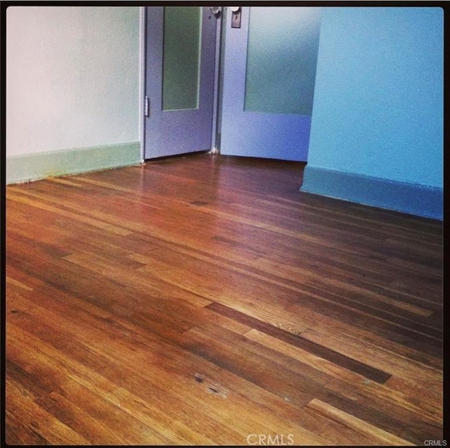 unfurnished room with dark wood-type flooring