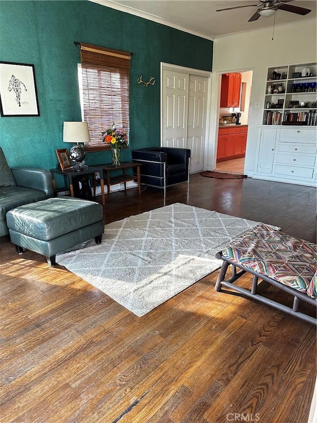 living room featuring crown molding, ceiling fan, and wood finished floors