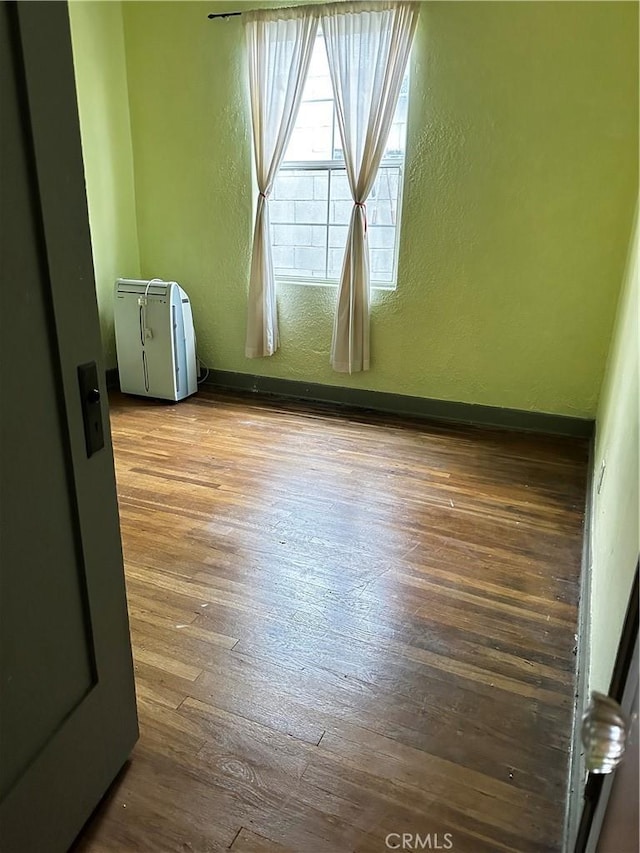 4943 Granada St, Los Angeles, CA 90042 - spare room with hardwood / wood-style flooring, a textured wall, and baseboards