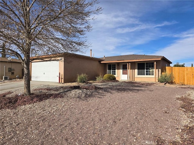 single story home featuring central AC and a garage